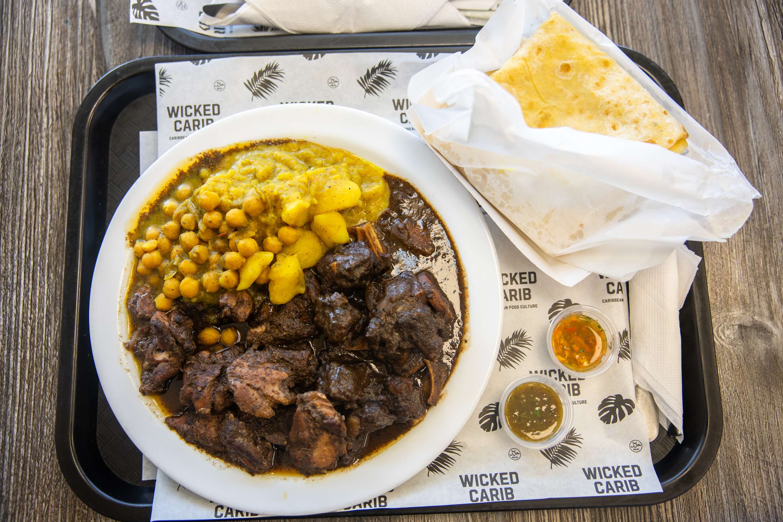 Curry goat with rice and house-made chutneys served at Wicked Carib in Scarborough.